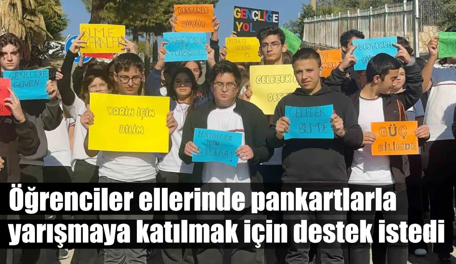 Öğrenciler ellerinde pankartlarla yarışmaya katılmak için destek istedi